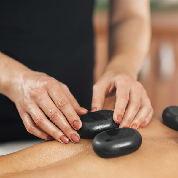 Stone Massage Stone massage back treatment with volcanic stones in a spa center